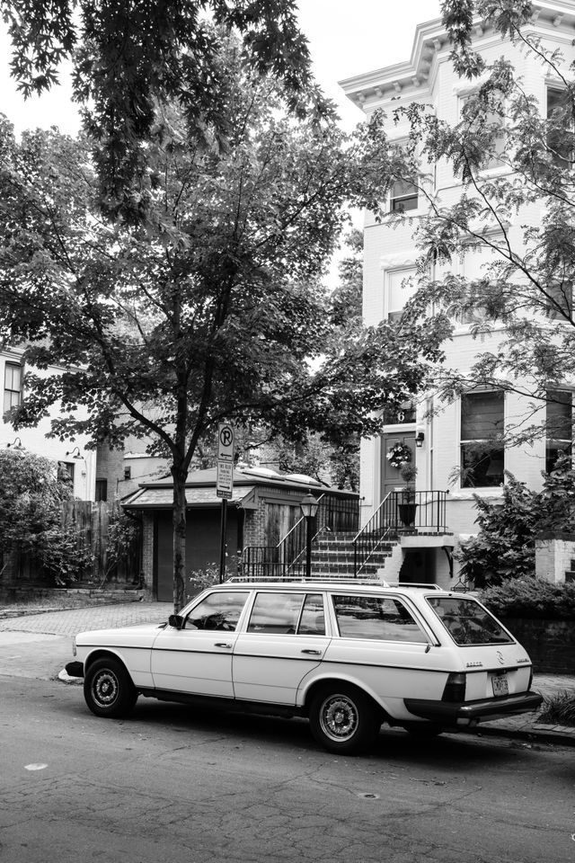 A Mercedes station wagon parked in front of a row house in Capitol Hill.