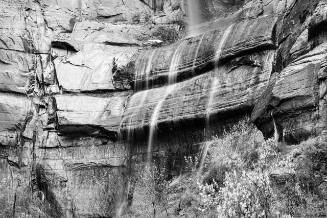 Water from a waterfall in the Temple of Sinawava, running off of some rocks.