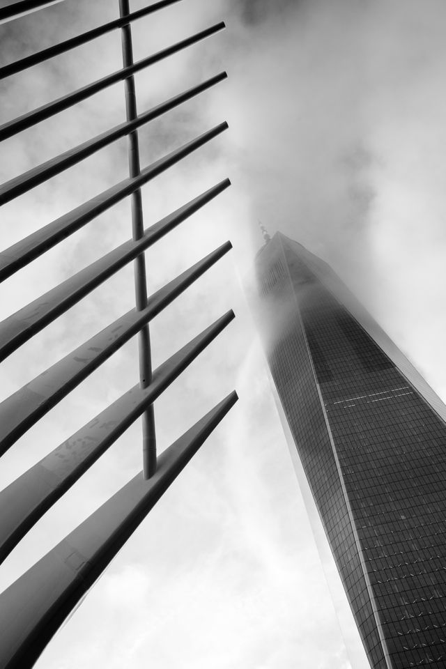 The World Trade Center shrouded in fog, seen next to the ribs of the Oculus.