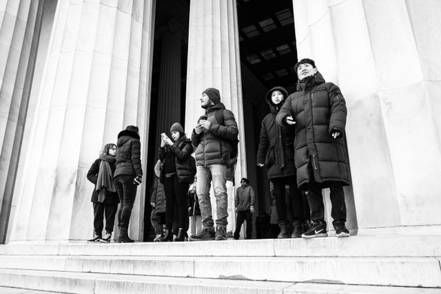 A group of people looking at the view from the top of the stairs of the Lincoln Memorial.