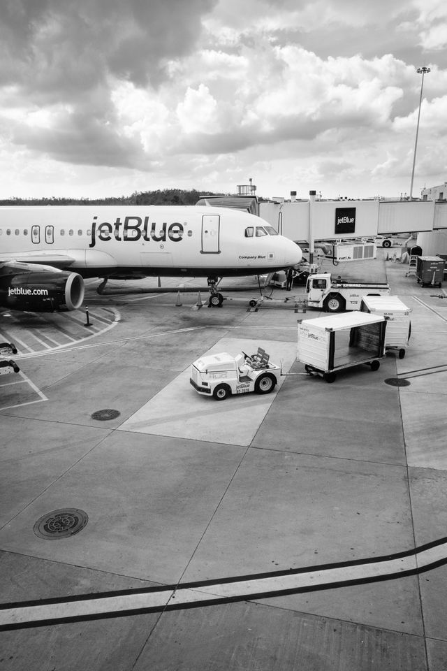 A jetBlue Airbus A320, "Company Blue", parked at a gate at Orlando International Airport.