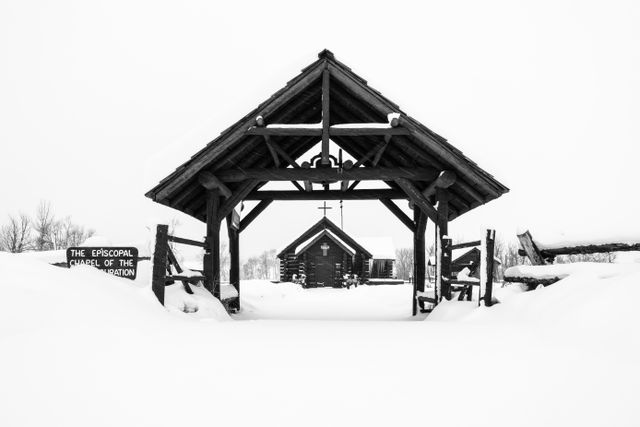 The entrance canopy of the Chapel of the Transfiguration, with the Chapel itself in the background, under overcast skies on a snowy day. The ground is covered in several inches of snow.