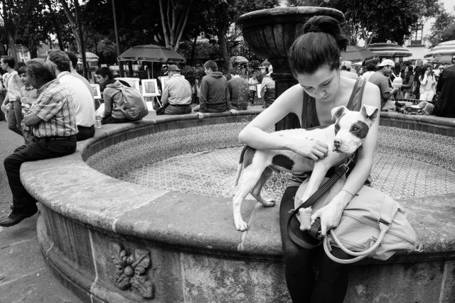 A girl holding a pupper at Plaza de San Jacinto, Mexico City.