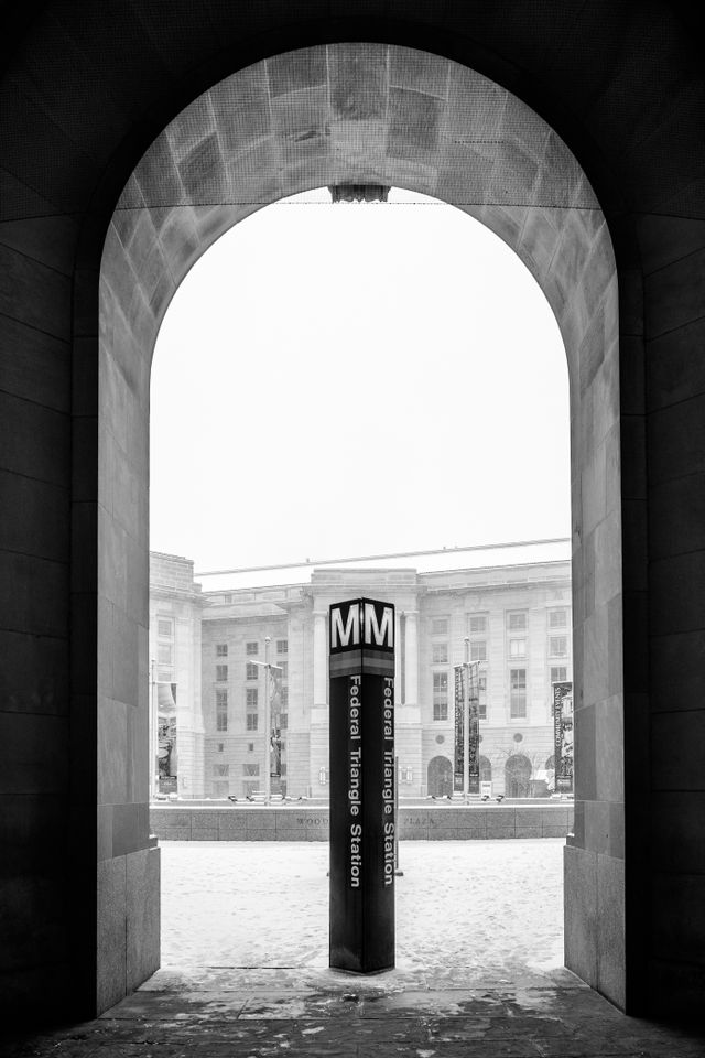 The arched exit of the Federal Triangle Metro Station at the Ronald Reagan Building, with the Metro sign under it.