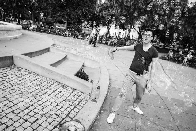 A man blowing soap bubbles at Dupont Circle.