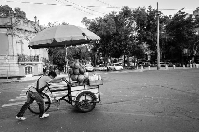 A man pushing a coconut cart at Roma Norte, Mexico City.