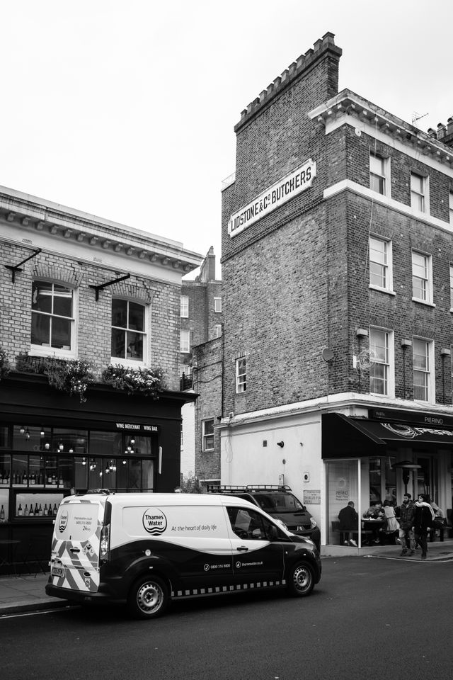 A Thames Water van parked on the street in front of a building with a Lidstone & Co. Butchers sign.