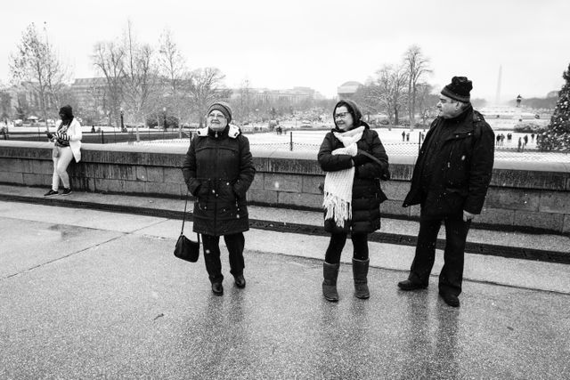 Tourists looking at the Capitol building on a snowy day in DC.