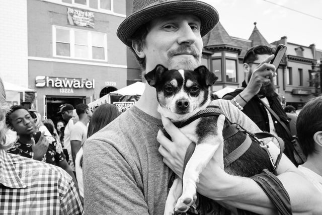 A man holding a cute dog at the H Street Festival in Washington, DC.