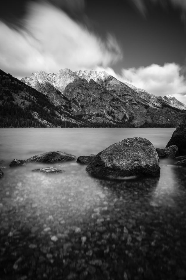 A long exposure of the shores of Jenny Lake in Grand Teton National Park. In the background, Mount Saint John.