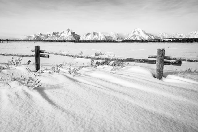 The Teton Range, seen in winter from Elk Ranch Flats. A wooden cattle fence and sagebrush in wind-swept snow can be seen in the foreground.