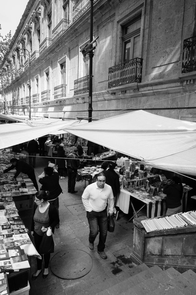 A man walking on a book market on the street in Mexico City.