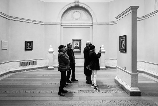 People taking a photo of the painting of Ginevra de' Benci by Leonardo da Vinci, at the National Gallery of Art.