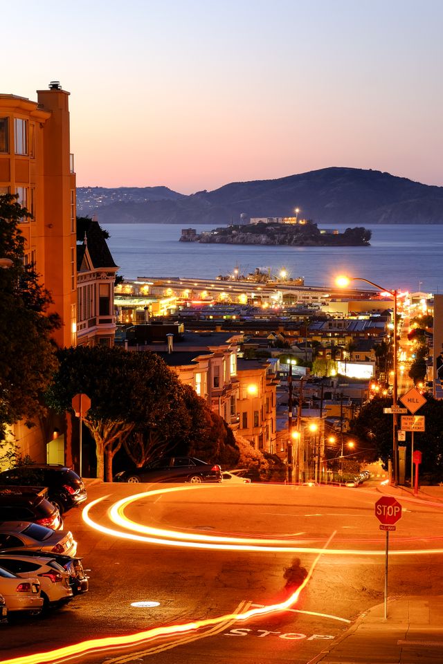 Taylor Street in San Francisco, at dusk, with Alcatraz Island in the distance.