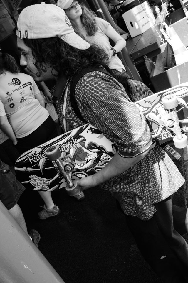 A man carrying a skateboard near Pike Place Market in Seattle, Washington.