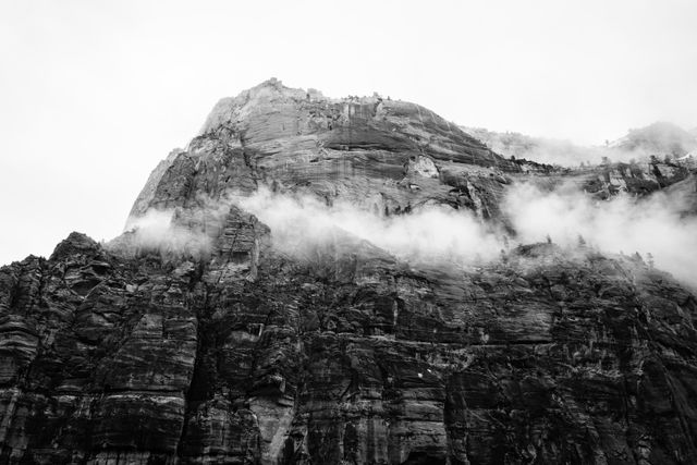 The side of the Great White Throne, seen from the Kayenta Trail, partially shrouded in fog.