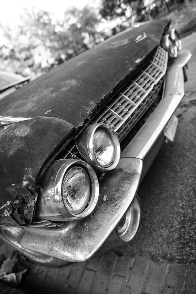 Front right corner of a rusted 1960s Cadillac de Ville parked on 9th Street & K Street NE in Washington, DC.