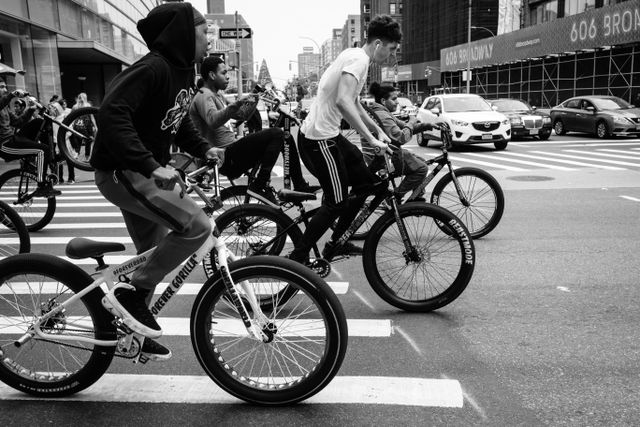 A group of teenagers on bicycles on Broadway & Houston Street, near Soho, Manhattan.