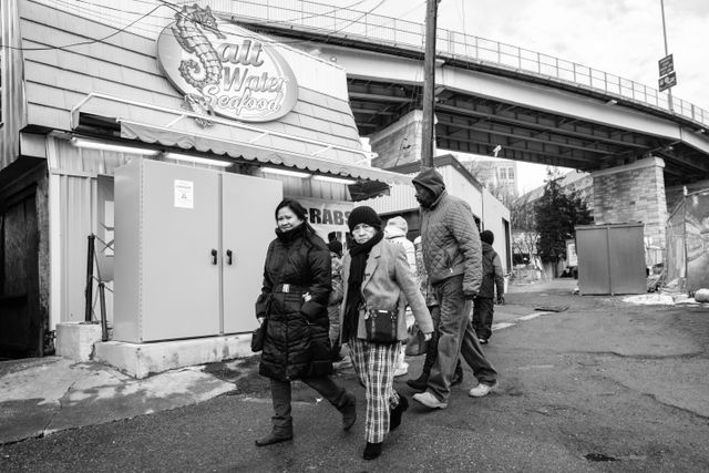 A group of people walking towards the Maine Avenue Fish Market in Washington, DC.