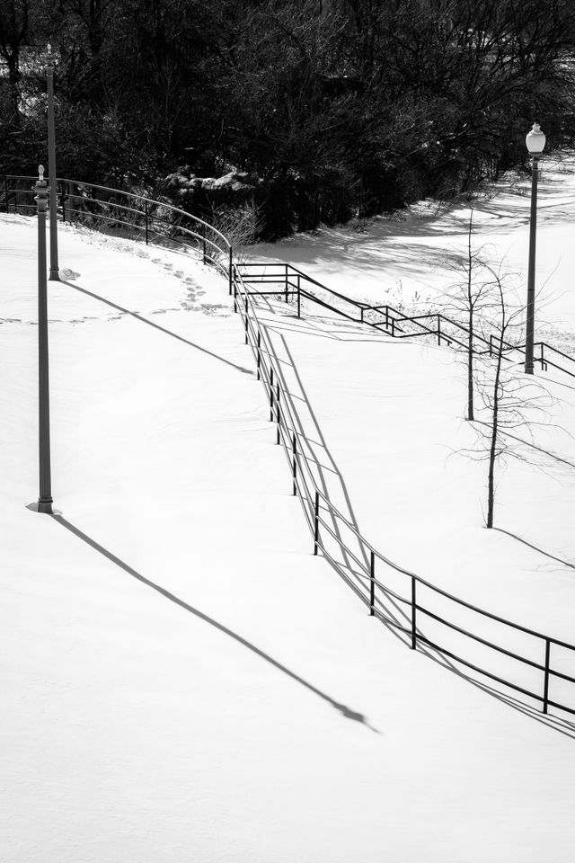 A curved fence in a snow-covered Anacostia Park.