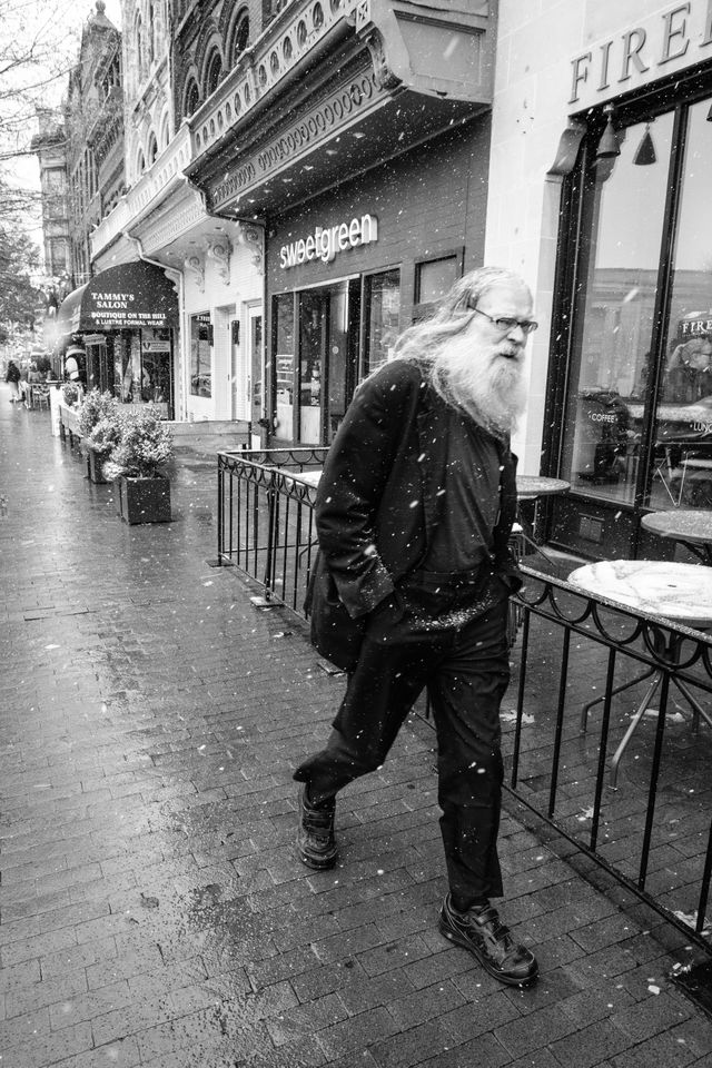 A man walking very briskly on Pennsylvania Avenue SE.