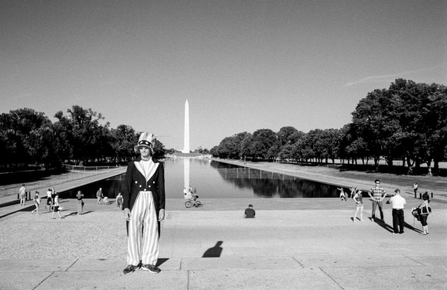 A person dressed as Uncle Sam in front of the Reflecting Pool.