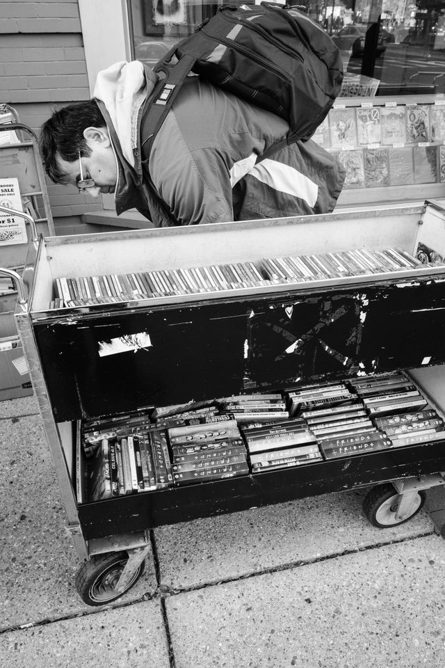 A man looking at DVDs in an outdoor stand outside Second Story Books in Dupont Circle.