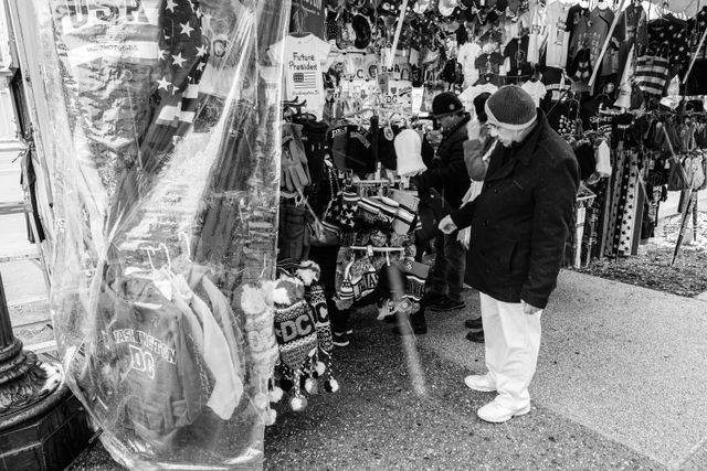 A tourist looking at wares on a street vendor's truck on the National Mall.