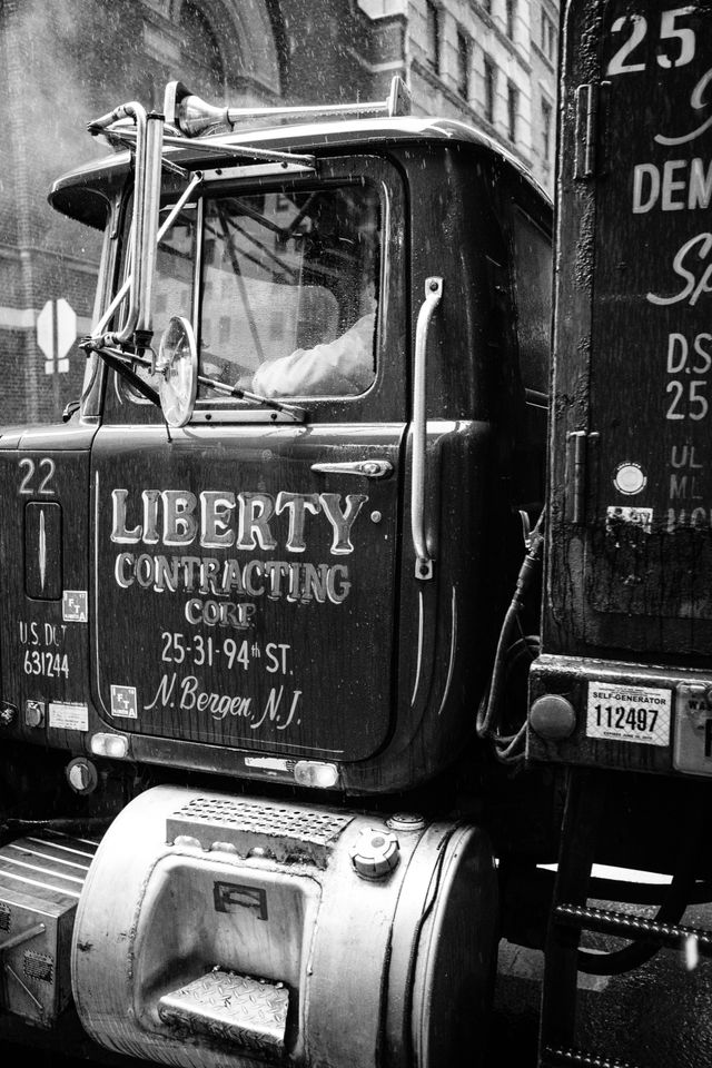 A truck in the rain on William Street. It has "Liberty Contracting Corp." written on the door in beautiful hand lettering.