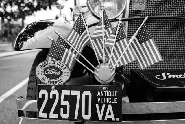 A Ford Model A with a bunch of American flags on the front bender.