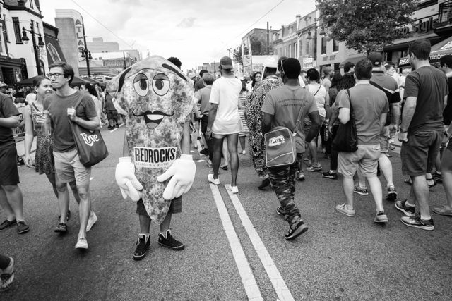 A man standing on the street in a pizza costume, at the H Street Festival in Washington, DC.