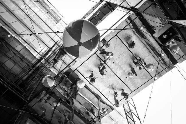 Beachballs hanging at CityCenterDC, with people reflected off the shiny ceiling.