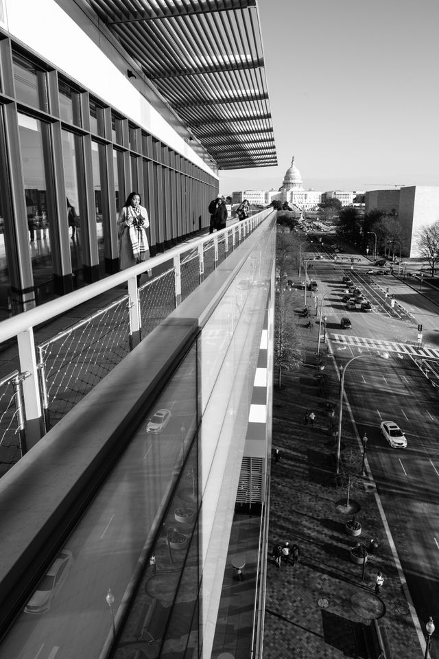 A woman walking along the terrace of the Newseum in Washington, DC.