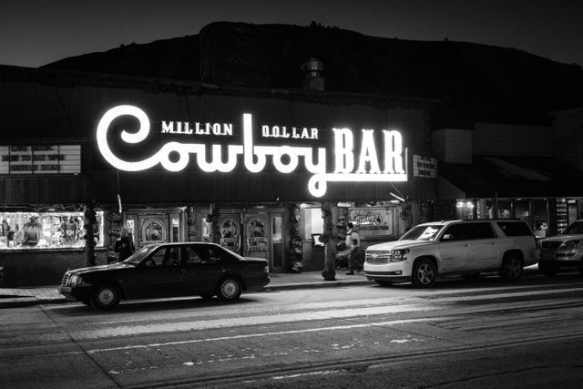 The sign of the Million Dollar Cowboy Bar in Jackson, Wyoming, lit up at night.