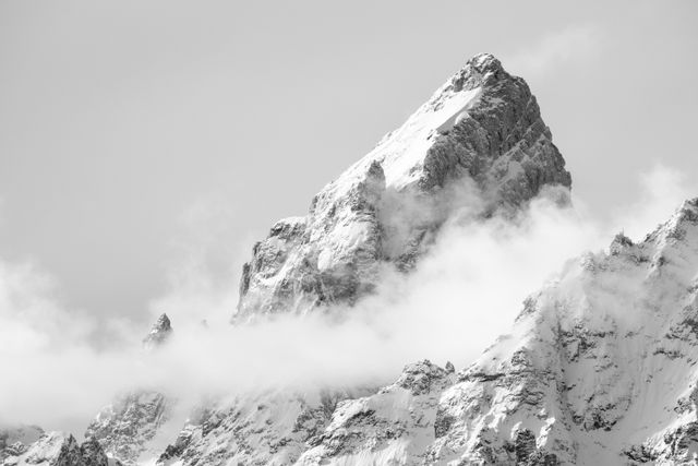 The snow-covered summit of Grand Teton, shrouded in clouds.