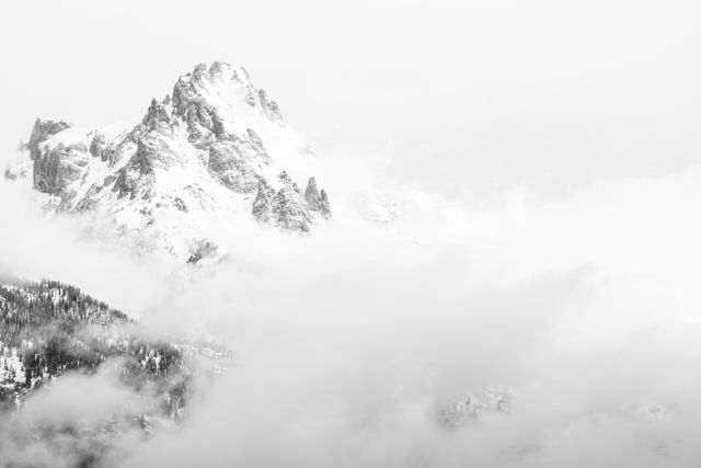 A storm clearing, revealing the summit of Teewinot Mountain.