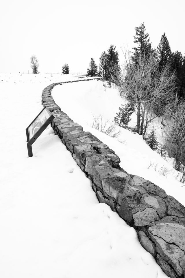 A stone wall on a very snow-covered Snake River Overlook.