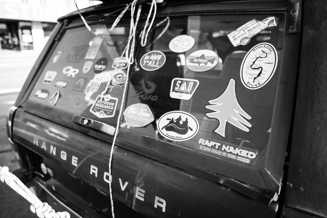 Stickers on the back window of a Range Rover at Starr Mountain Outfitters in Etowah, Tennessee. The one in the foreground reads "raft naked, it adds color to your cheeks".