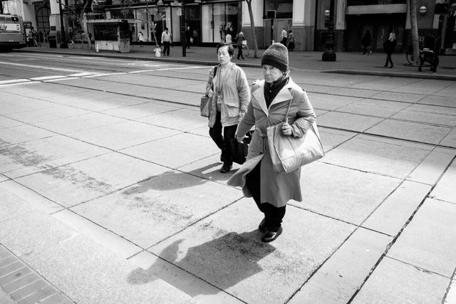 Two women crossing Market Street in San Francisco.