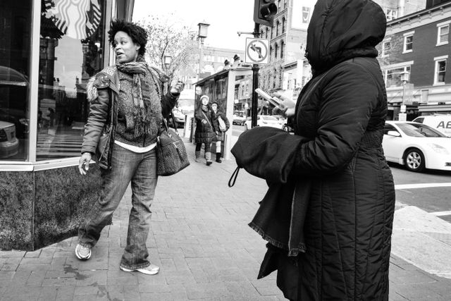 Two women posing for photos outside a Starbucks in Chinatown, Washington, DC.