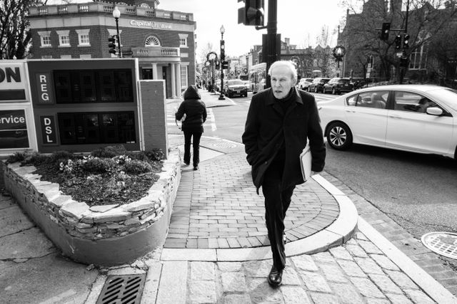 A man walking past an Exxon gas station in Georgetown.