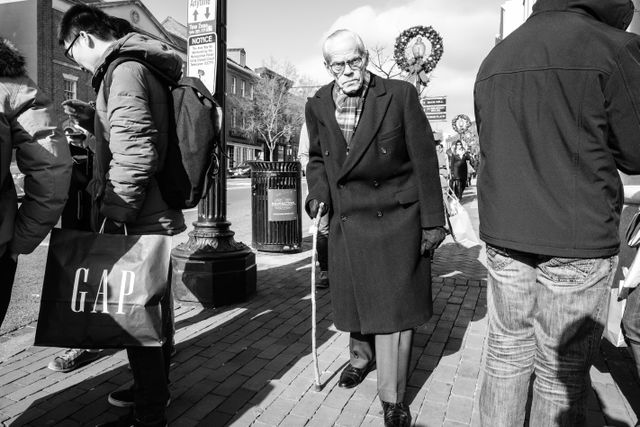 A man with a cane on Wisconsin Avenue NW in Georgetown.