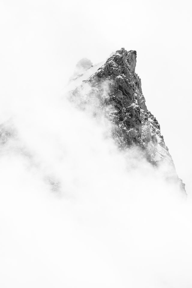 The summit of Teewinot Mountain, surrounded by clouds.