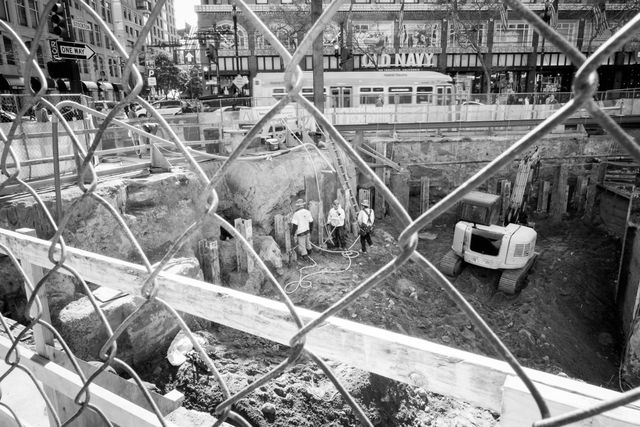 A group of construction workers seen through a chainlink fence on Stockton & Market, San Francisco.