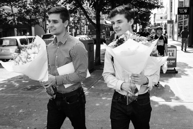 Two young men carrying flower bouquets on Pine Street in Seattle.