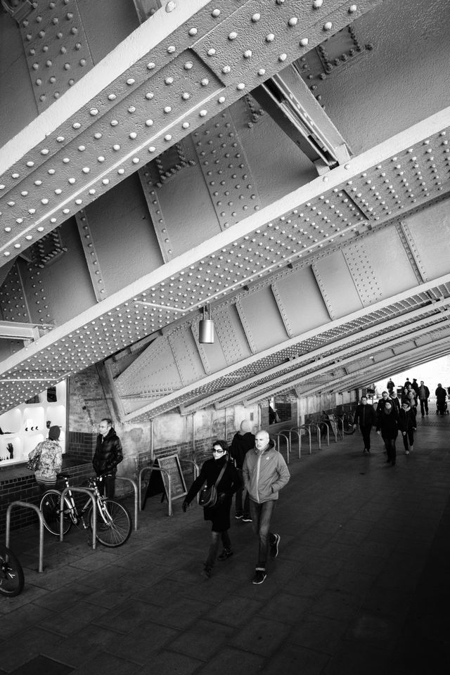 Pedestrians walking under the Blackfriars Bridge.